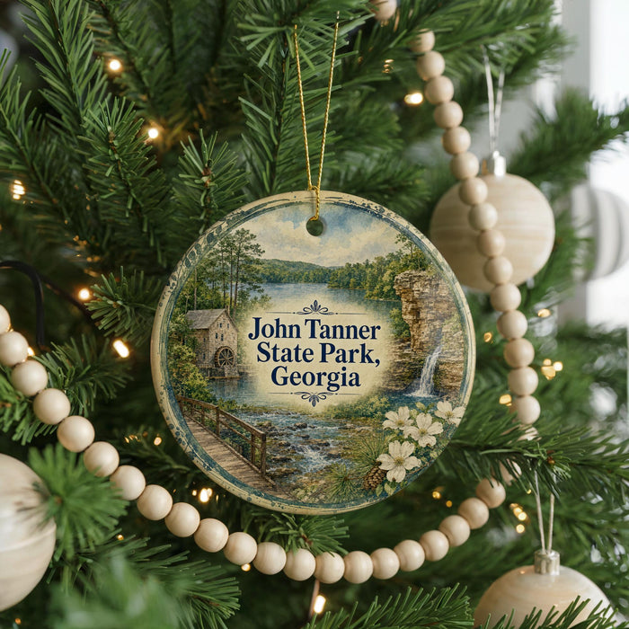 A round ornament hanging on a Christmas tree, featuring a scenic image of John Tanner State Park in Georgia.