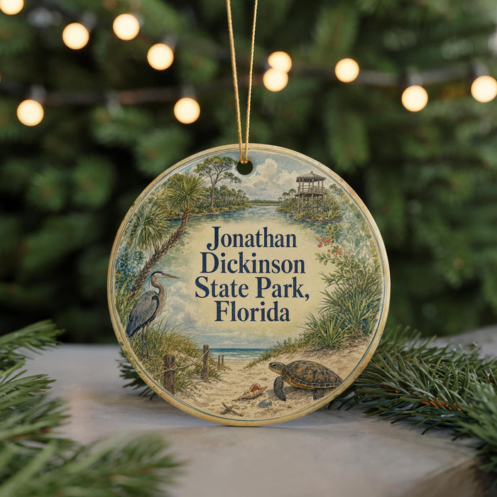 A circular ornament with a beach scene and a bird on it, hanging from a string.