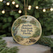 A circular ornament with a beach scene and a bird on it, hanging from a string.