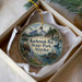 A circular ornament with a scenic landscape of Kachemak Bay State Park, Alaska, featuring a bald eagle, a walrus, and other wildlife.
