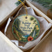 A circular ornament with a tropical landscape design, featuring palm trees, a waterfall, and a hibiscus flower, is displayed in a white box.