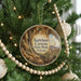 A round ornament hanging on a Christmas tree, featuring a scenic image of the Kartchner Caves in Arizona.