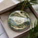 A decorative ornament in a box, featuring a scenic image of Kaw River State Park in Kansas.