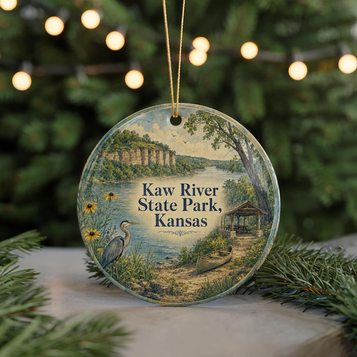 A circular ornament featuring a scenic image of Kaw River State Park, Kansas, with a bird, canoe, and other natural elements.