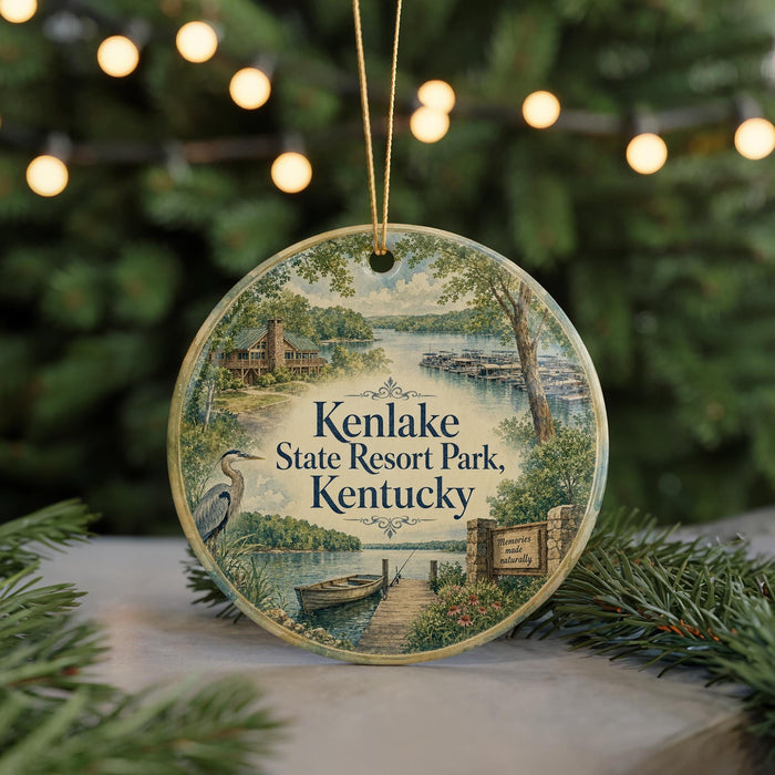 A round ornament with a scenic view of Kenlake State Resort Park, Kentucky, featuring a lake, a cabin, and a bird.