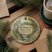 A decorative ornament featuring a scenic image of kettletown state park in Connecticut, surrounded by pine branches and a cup of coffee on a wooden surface.