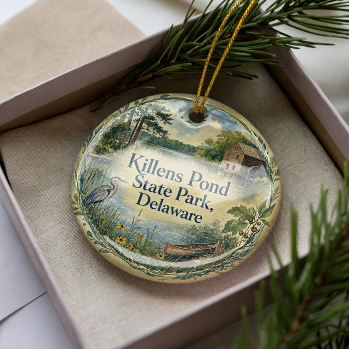 A decorative ornament in a box, featuring a scenic image of Killens Pond State Park in Delaware.