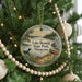A round ornament hanging on a Christmas tree, featuring a scenic image of Lake Bemidji State Park in Minnesota.
