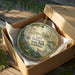 A decorative ornament in a wooden box, featuring a scenic image of Lake Bistineau State Park in Louisiana.