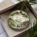 A decorative ornament featuring a scenic landscape of Lake Bronson State Park, Minnesota, with pine trees and a lake in the background.