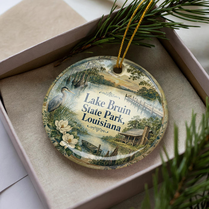 A decorative ornament in a box, featuring a scenic image of Lake Bruin State Park in Louisiana.