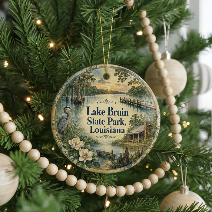 A round ornament hanging on a Christmas tree, featuring a scenic image of Lake Brun State Park in Louisiana.