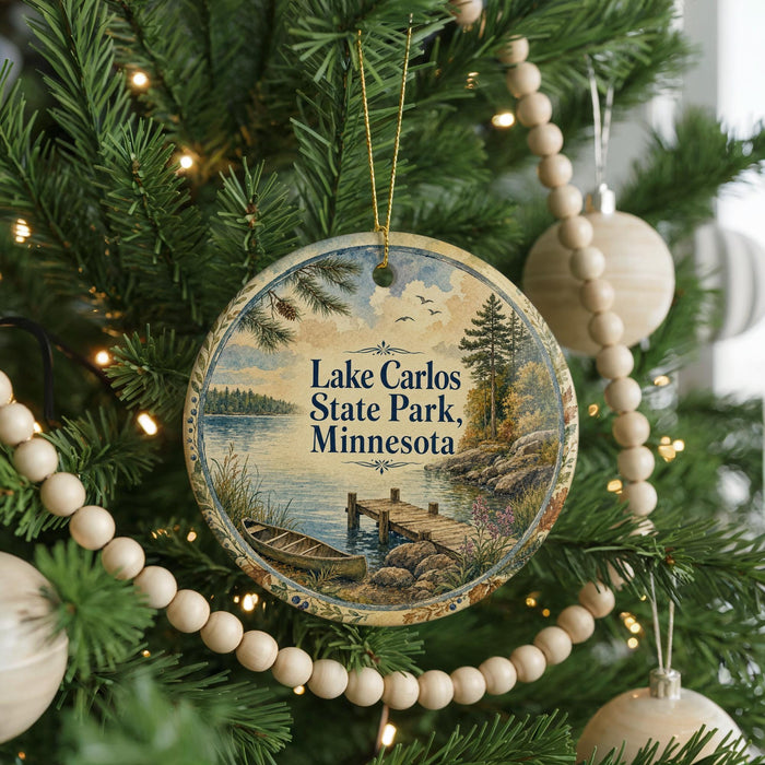 A round ornament hanging on a Christmas tree, featuring a scenic image of Lake Carlos State Park in Minnesota.