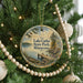 A round ornament hanging on a Christmas tree, featuring a scenic image of Lake Carlos State Park in Minnesota.