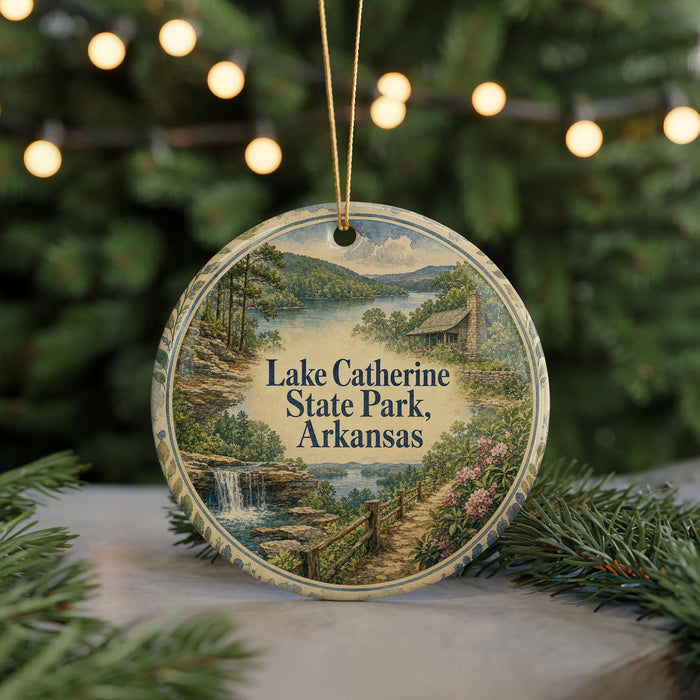 A round ornament with a scenic landscape of Lake Catherine State Park, Arkansas, featuring a waterfall and a cabin in the background.