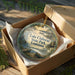 A decorative ornament in a box, featuring a scenic image of Lake Claiborne State Park in Louisiana.