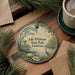 A decorative ornament with a scenic image of Lake D'Arbonne State Park in Louisiana, featuring a bird, flowers, and a pond.