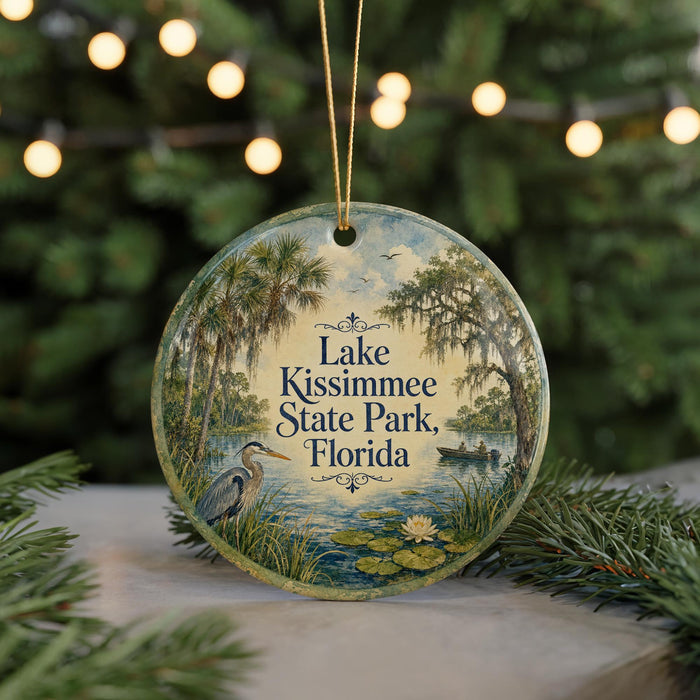 A round ornament with a painting of a lake, palm trees, and a bird, hanging on a string.