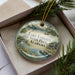 A decorative ornament with a scenic lake and forest landscape, featuring the text "Lake Lureen State Park, Alabama" on it.