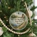 A round ornament hanging on a Christmas tree, featuring a scenic image of Lake Macbride State Park in Iowa.