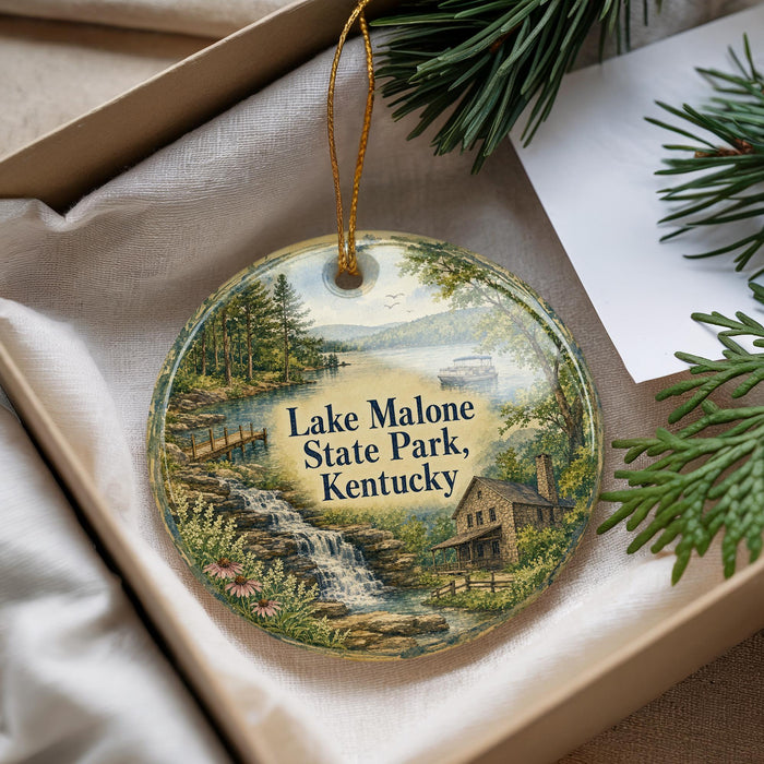 A decorative ornament with a scenic landscape of Lake Malone State Park, Kentucky, featuring a waterfall, pine trees, and a cabin.