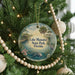 A round ornament hanging on a Christmas tree, featuring a scenic image of Lake Manatee State Park, Florida.