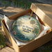 A decorative ornament in a box, featuring a scenic image of Lake Manatee State Park, Florida.