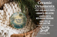 Ceramic ornaments, including a round ornament with a palm tree and a bird, are displayed in a basket.