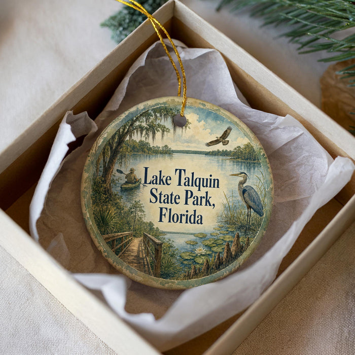 A decorative ornament in a box, featuring a scenic image of Lake Talquin State Park in Florida.