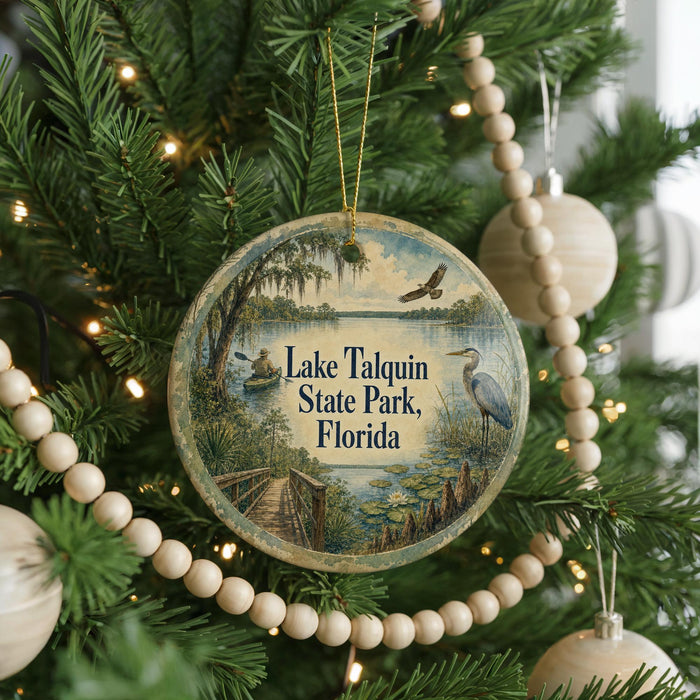 A circular ornament hanging on a Christmas tree, featuring a scenic image of Lake Talquin State Park in Florida.