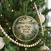 A circular ornament hanging on a Christmas tree, featuring a scenic image of Lake Talquin State Park in Florida.