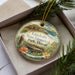A decorative ornament in a box, featuring a scenic image of Lapakahi State Historical Park in Hawaii.