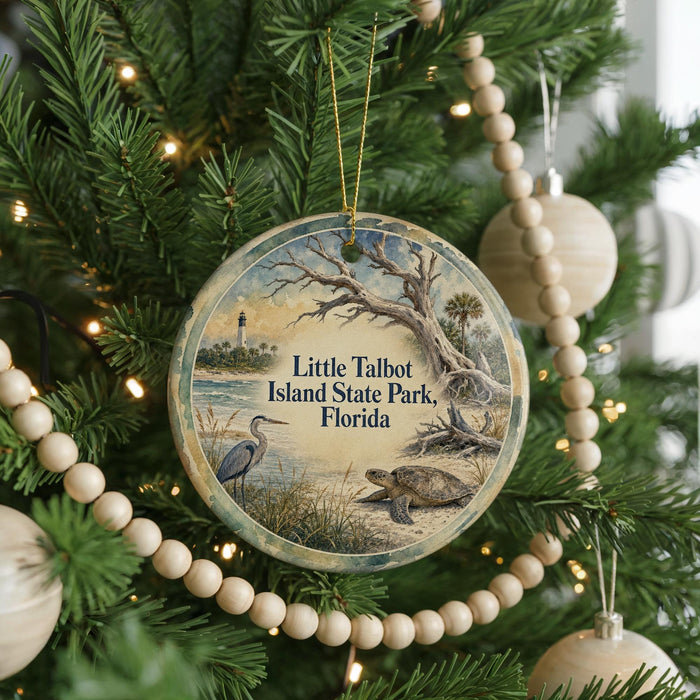 A round ornament hanging on a Christmas tree, featuring a scenic image of a bird, a lighthouse, and a turtle, with the text "Little Talbot Island State Park, Florida" displayed on it.