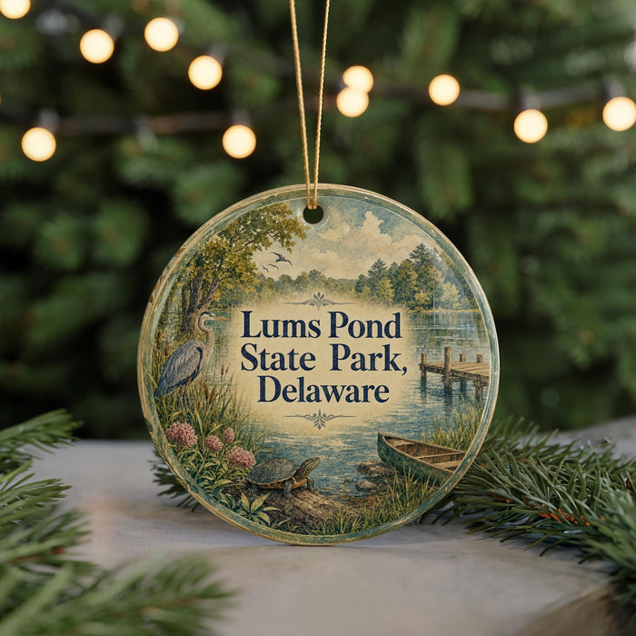 A round ornament with a painting of a pond and trees, featuring the text "Lums Pond State Park, Delaware" in the center.