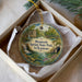 A decorative ornament in a box, featuring a scenic image of Mammoth Spring State Park in Arkansas.