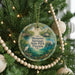 A circular ornament hanging on a Christmas tree, featuring a scenic image of Manatee Springs State Park, Florida.