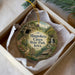 A decorative ornament in a box, featuring a scenic image of the Maquoketa Caves State Park, Iowa.