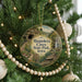 A circular ornament hanging on a Christmas tree, featuring a scenic image of the natural beauty of the state park in Iowa.