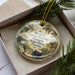 A decorative ornament in a box, featuring a vintage-style illustration of a horse, trees, and a typewriter, with the text "Marjorie Kinnan Rawlings Historic State Park, Florida" printed on it.