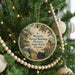 A round ornament hanging on a Christmas tree, featuring a vintage-style illustration of a house and a horse, with the text "Marjorie Kinnan Rawlings Historic State Park, Florida" printed on it.