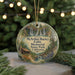 A round ornament with a scenic illustration of a waterfall and forest, hanging from a string.