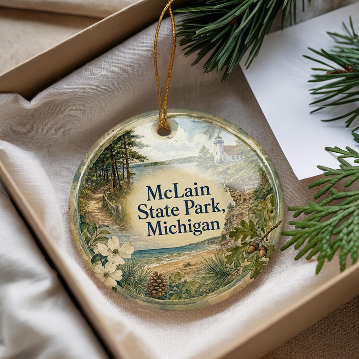 A decorative ornament with a scenic landscape of a lake, forest, and mountains, featuring the text "McLain State Park, Michigan".