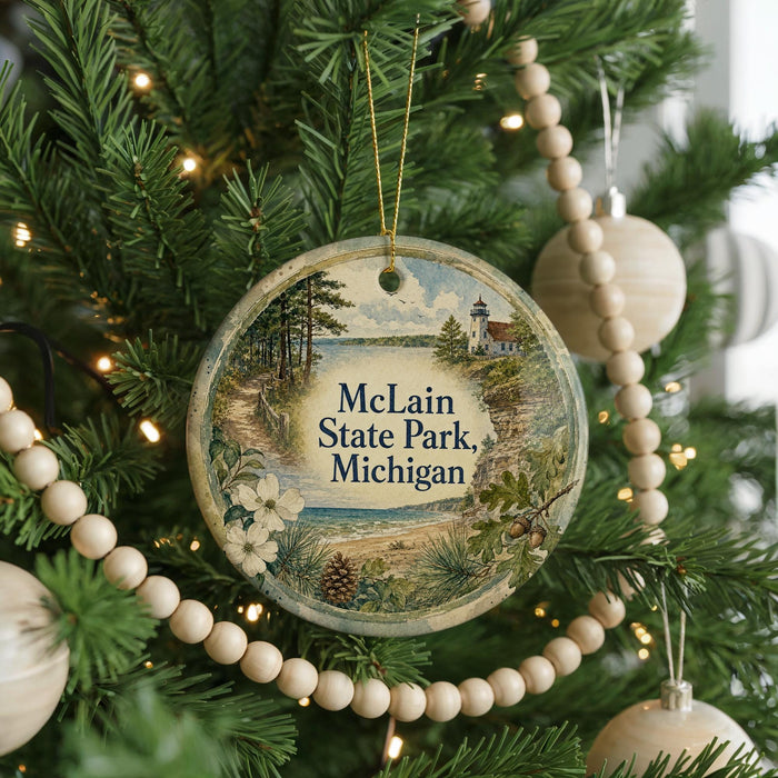A round ornament hanging on a Christmas tree, featuring a scenic image of Michigan State Park.