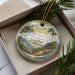 A decorative ornament with a scenic landscape of Mendocino Headlands, California, featuring a coastal scene with a lighthouse, pine trees, and a body of water.