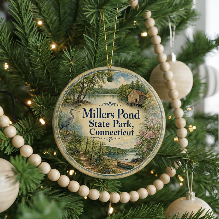 A round ornament hanging on a Christmas tree, featuring a scenic image of Millers Pond State Park in Connecticut.