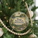 A Christmas tree decorated with ornaments, including a circular ornament with a scenic view of Moore State Park, Massachusetts.
