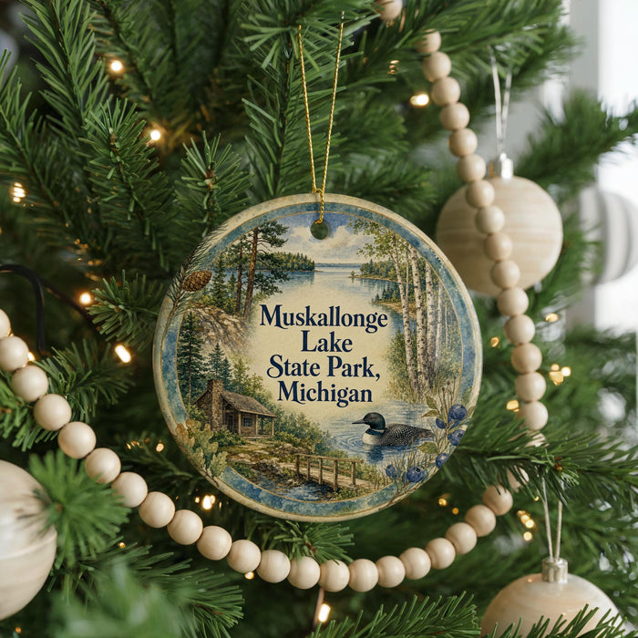 A circular ornament hanging on a Christmas tree, featuring a scenic image of Muskallon Lake State Park in Michigan.