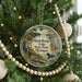 A circular ornament hanging on a Christmas tree, featuring a scenic image of Muskallon Lake State Park in Michigan.