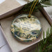 A decorative ornament in a box, featuring a scenic image of Kentucky State Park and a house, with the text "My Old Kentucky Home State Park, Kentucky" printed on it.