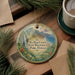 A decorative ornament with a scenic image of the Na Pali Coast State Wilderness Park in Hawaii, featuring lush greenery, a waterfall, and the ocean.